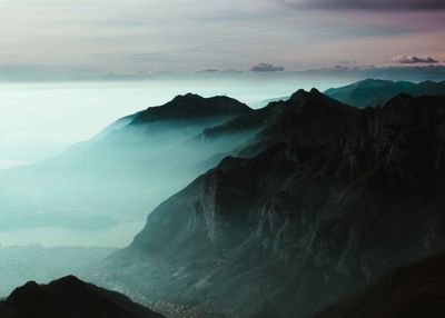 Scenic view of mountain range against cloudy sky