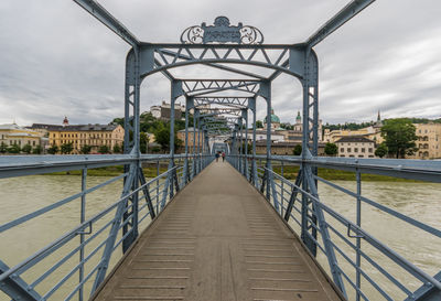 Footbridge over river against sky