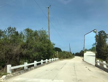 Road by trees against sky