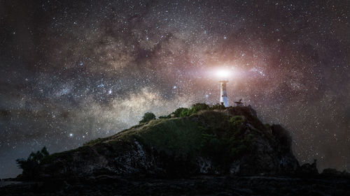 Low angle view of rock formation against star field