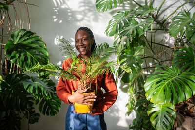 Portrait of woman standing against plants