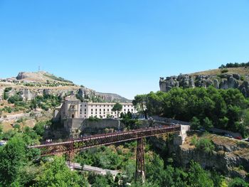 Bridge over mountain against clear blue sky