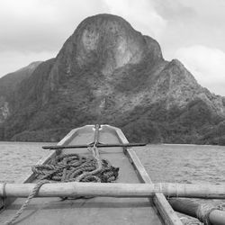 Boat on rock by sea against sky