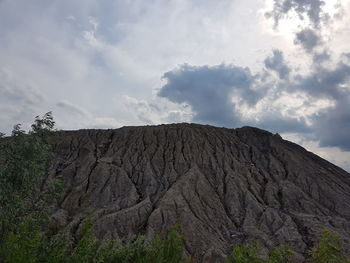 Low angle view of volcanic mountain against sky