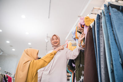 Portrait of smiling mother with daughter in clothing store