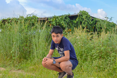 Full length of boy sitting on field