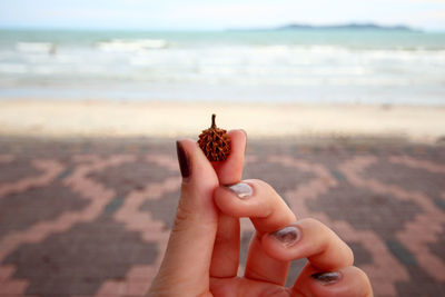 Midsection of woman holding hands at beach