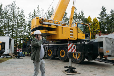 Foreman talking by phone on construction site. architect discussing project using smart phone