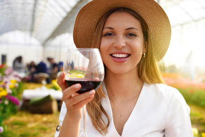 Photo of happy cheerful woman holds wine glass makes toast lookng at camera 