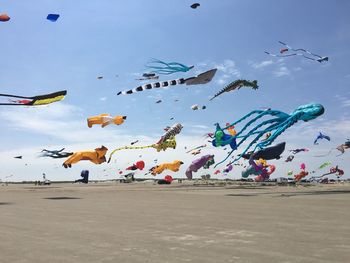 Low angle view of kites flying over beach against sky