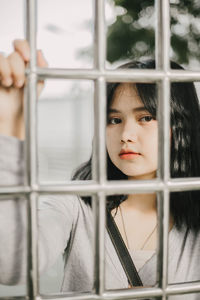 Portrait of girl looking through window