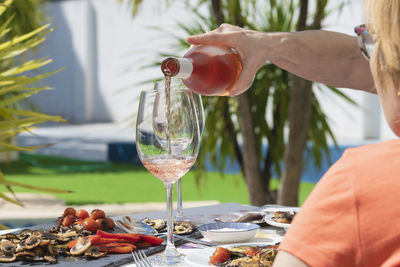 A hand of woman pouring delicious rose wine