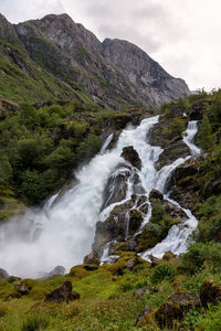 Scenic view of waterfall against sky