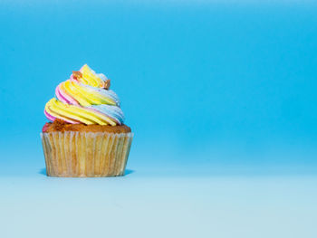 Low angle view of cupcakes against blue background
