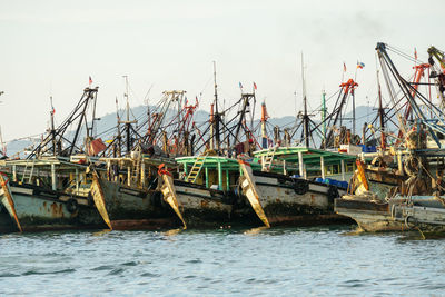 Fishing boats in sea against clear sky