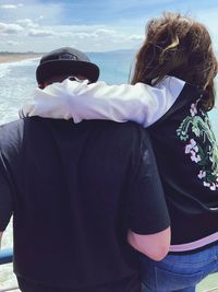 Rear view of man and woman standing in water