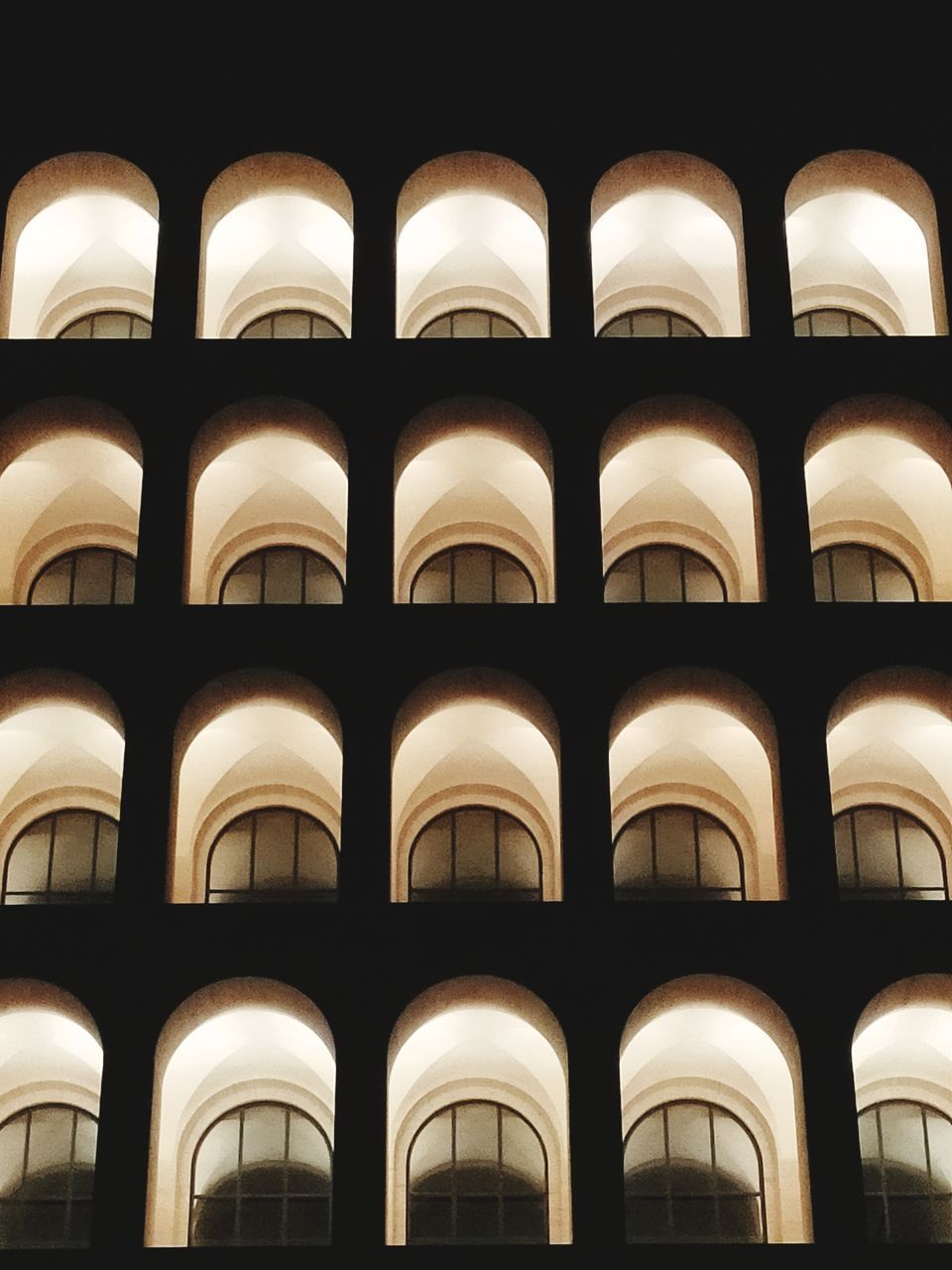 LOW ANGLE VIEW OF ILLUMINATED BUILDING IN ROW
