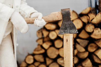 Hands of woman cutting wood log with axe