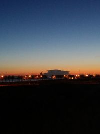 Illuminated cityscape against clear sky at night