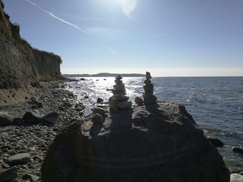 Scenic view of rocks on beach against sky