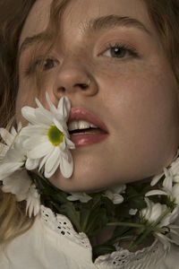 Close-up portrait of woman with red flower