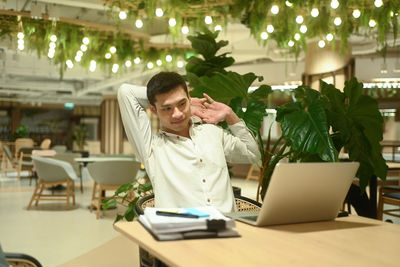 Young woman using mobile phone at table