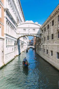 Man in gondola on grand canal against bridge of sighs