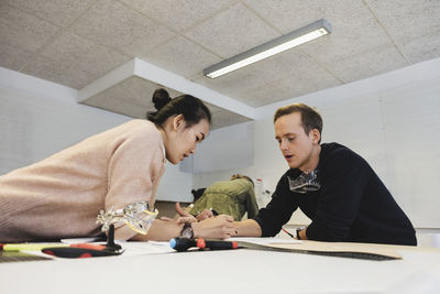 Engineers discussing about project on table in workshop