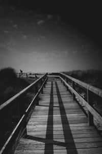 Pier on footbridge against sky