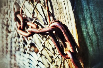 Close-up of rusty chain on wooden surface