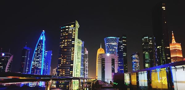 Low angle view of illuminated buildings against sky at night