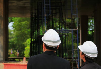 Rear view of man standing against built structure