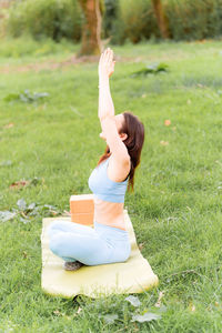 Full length of woman sitting on field