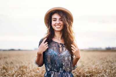 Portrait of smiling young woman standing in field