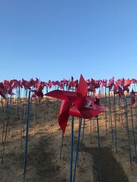 Red chairs on table against clear blue sky