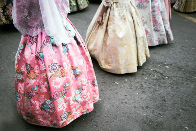 Low section of women wearing dress standing on road