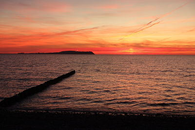 Scenic view of sea against orange sky