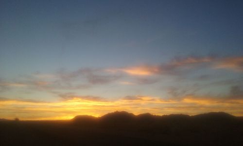 Scenic view of mountains against sky at sunset