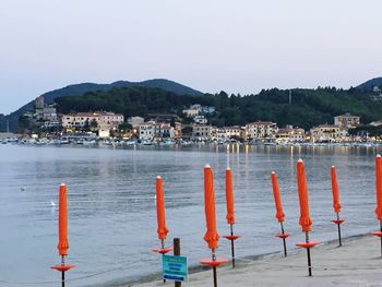 Sea and buildings in town against clear sky