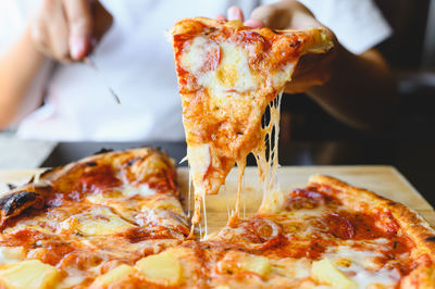 Close-up of hand holding pizza