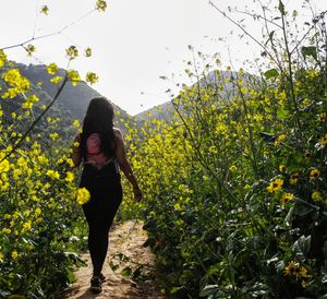 Young woman standing by plants