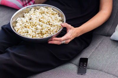 Midsection of man sitting in bowl at home