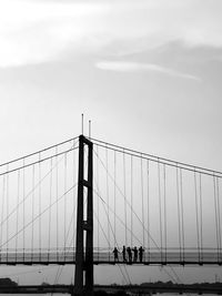 Low angle view of silhouette people on bridge against sky