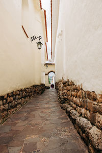 Footpath amidst buildings against wall