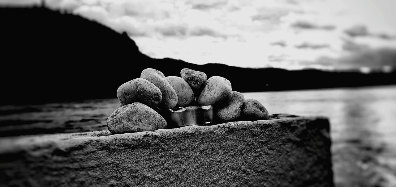 CLOSE-UP OF ROCKS ON SHORE AGAINST SEA