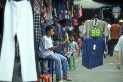 Rear view of people sitting on wall