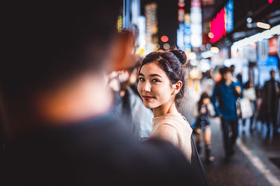 Smiling couple standing on street in city at night