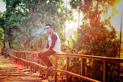 Full length of young man standing on footbridge