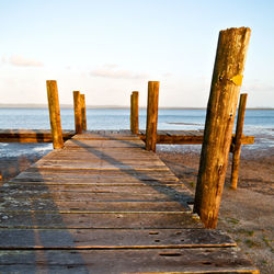 Wooden pier on sea against sky