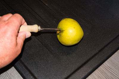 High angle view of man holding lemon on table